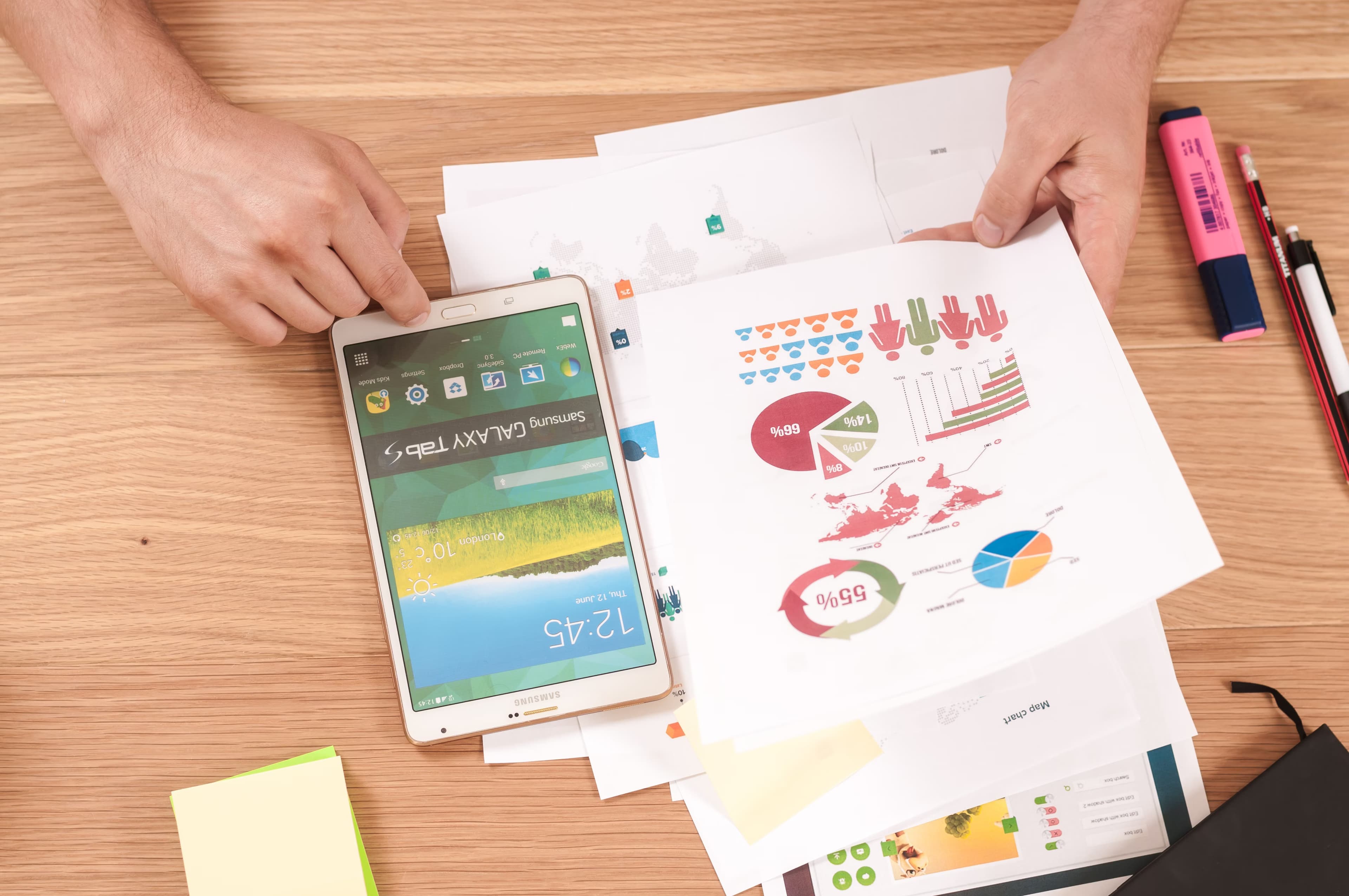 A piece of paper on a wooden table with charts on the paper and a phone on the table